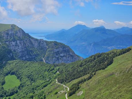 Travnaté vrcholky Monte Baldo s jezerem Lago di Garda v pozadí